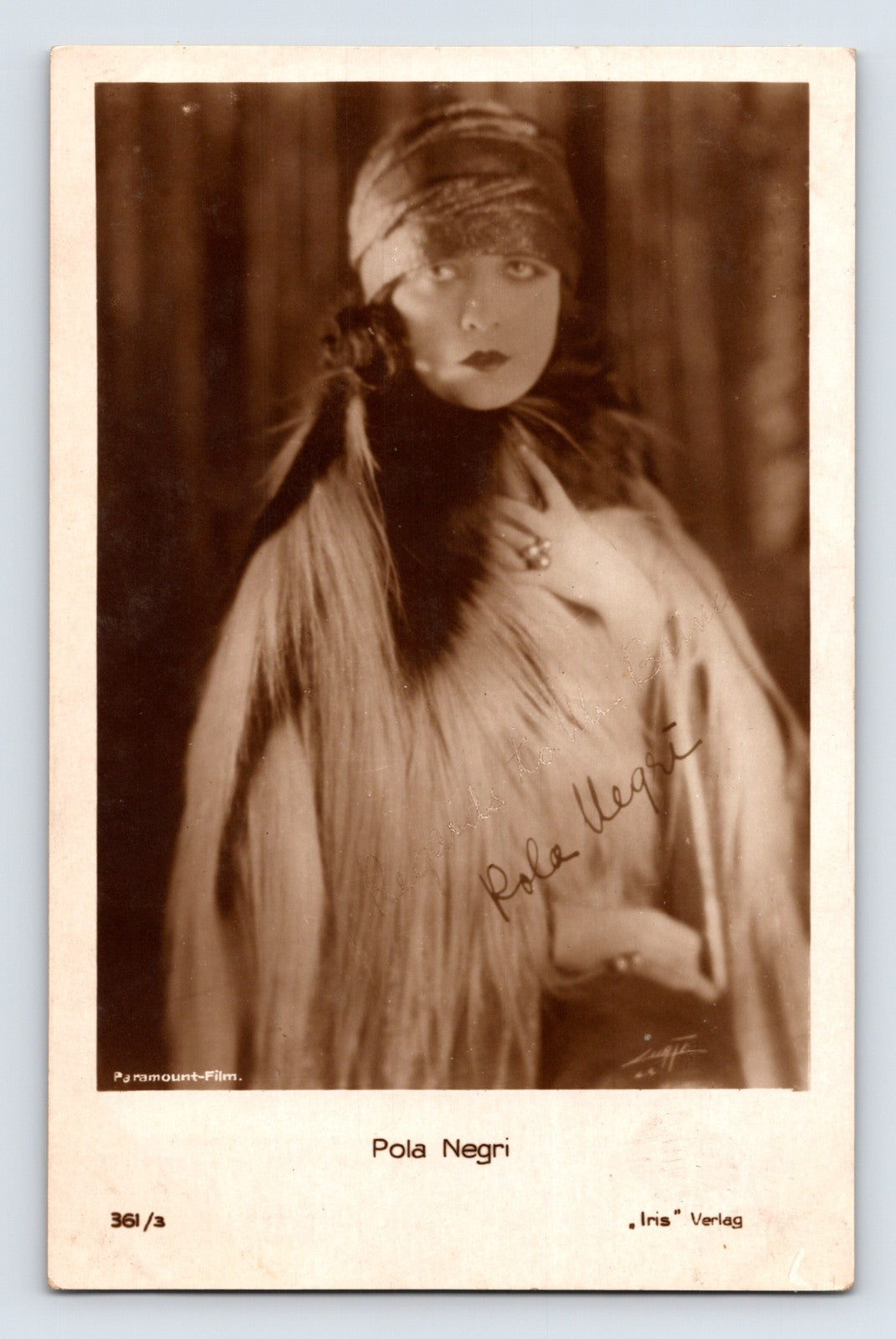 Sepia-toned real photo postcard portrait of silent film actress Pola Negri wearing an elaborate fur-trimmed wrap and headpiece in glamorous Paramount studio fashion.