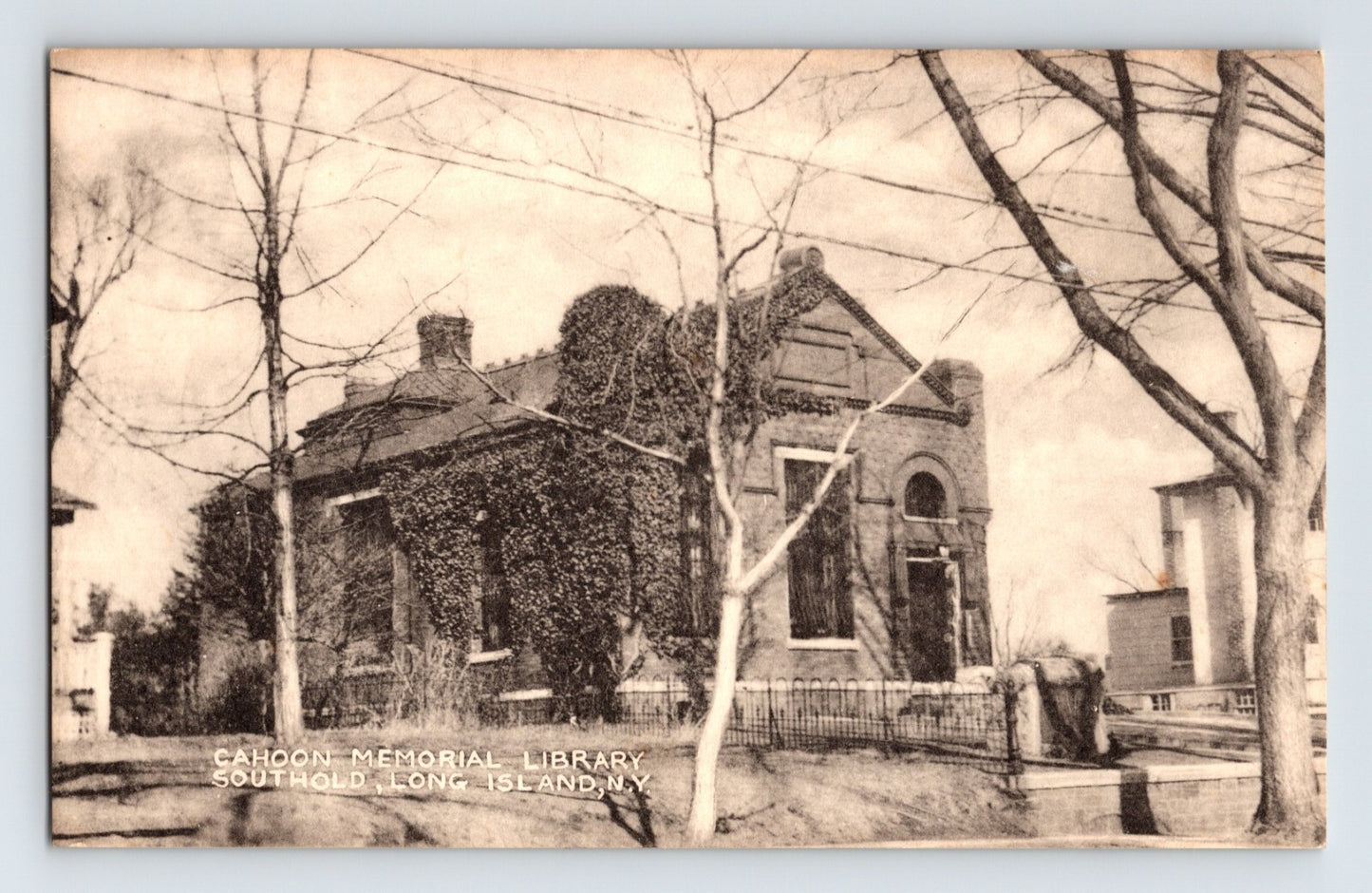 Vintage black and white photo of a library building with trees in front