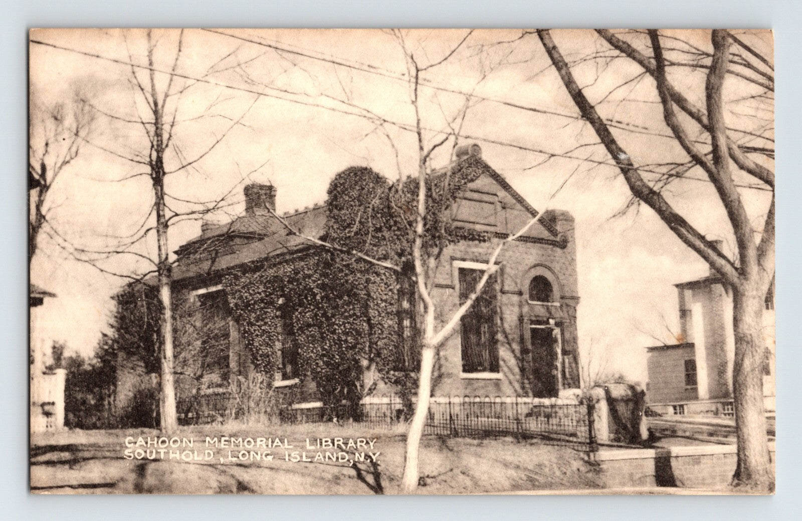 Vintage black and white photo of a library building with trees in front