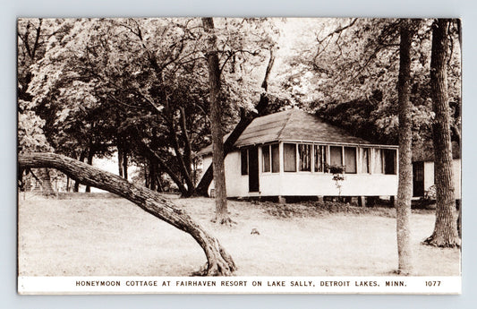 1940s postcard of Honeymoon Cottage at Fairhaven Resort in Detroit Lakes Minnesota showing small lakeside cabin surrounded by trees in quiet wooded setting