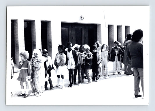 Children Halloween costume parade line outside school building snapshot photo 1960s