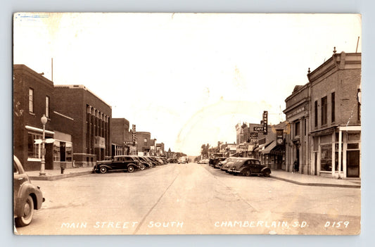 Chamberlain South Dakota Main Street view with parked cars storefronts Jennies Cafe signage 1940s RPPC postcard