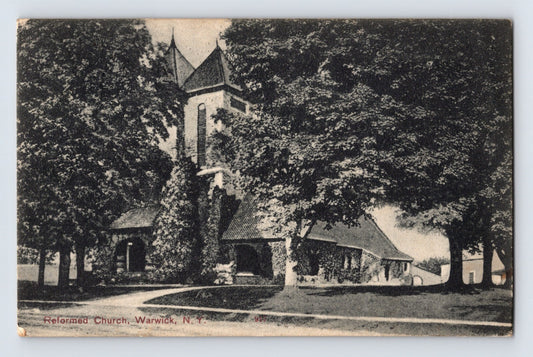 1907 postcard showing the Reformed Church in Warwick, New York, surrounded by mature trees and landscaped church grounds in a shaded village setting.