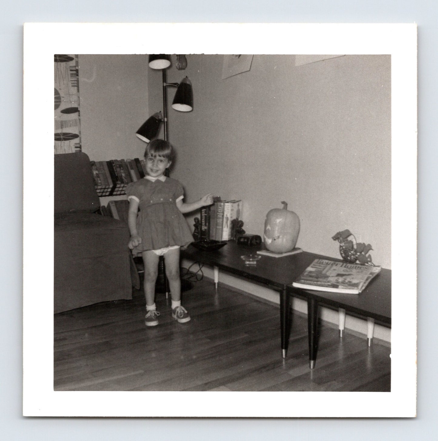 Vintage Halloween snapshot girl pumpkin jack o lantern mid century living room 1950s square photo