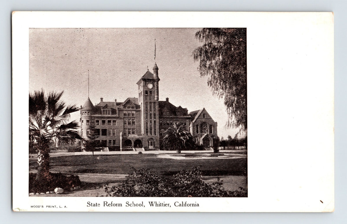 Early Whittier California State Reform School postcard showing brick institutional building with clock tower, palm trees, landscaped lawn, and undivided back format.