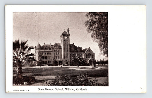 Early Whittier California State Reform School postcard showing brick institutional building with clock tower, palm trees, landscaped lawn, and undivided back format.