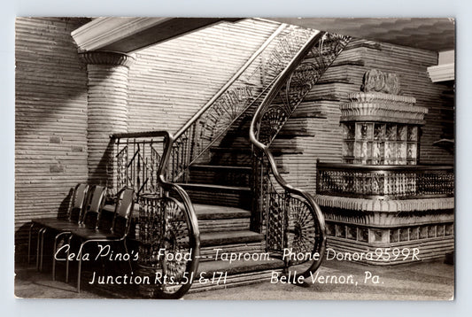 Black-and-white postcard interior view of Cela Pino’s Taproom in Belle Vernon, Pennsylvania, featuring an ornate curved staircase and decorative mid-century restaurant décor.