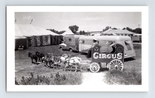 1962 black and white photograph of Fairyland Circus miniature horse-drawn wagon with circus sign, small trailer, and striped tents in background