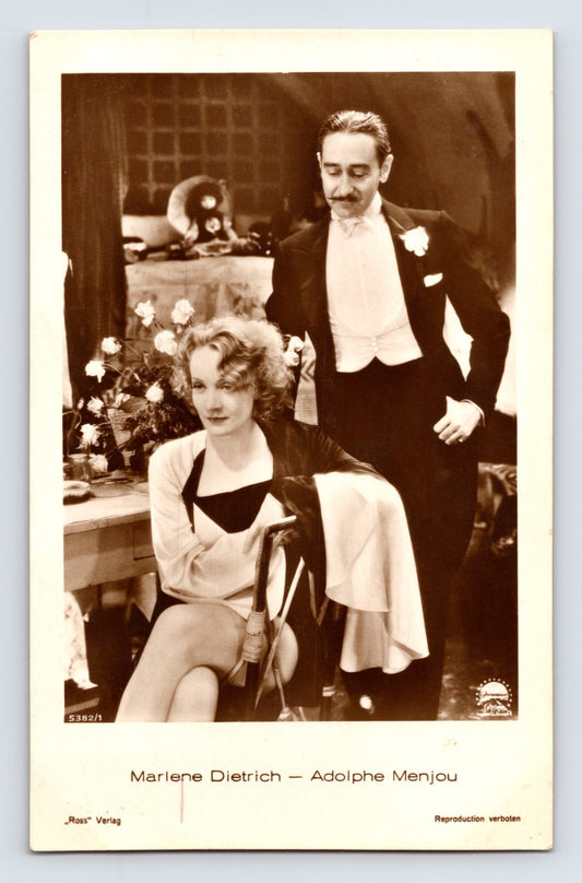 Marlene Dietrich seated with Adolphe Menjou formal scene Ross Verlag film still style postcard portrait 1930s