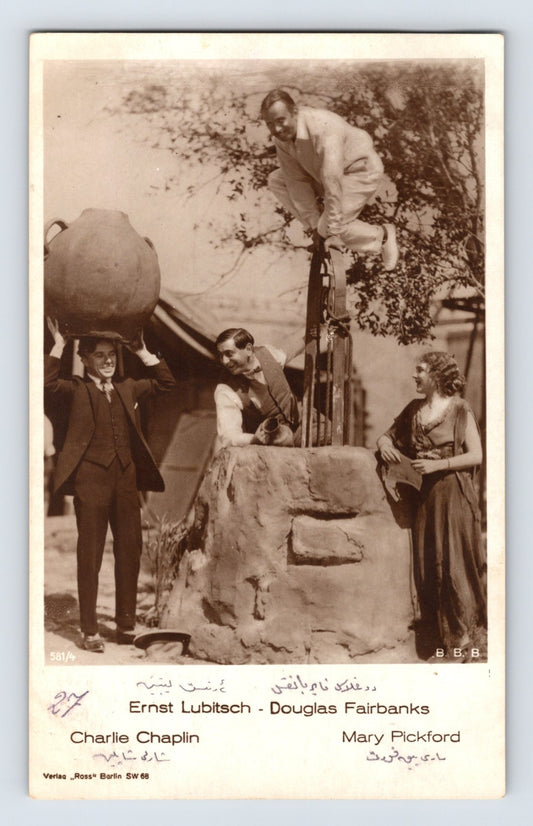Sepia real photo postcard showing Charlie Chaplin, Douglas Fairbanks, Mary Pickford, and Ernst Lubitsch posed around a well with printed names beneath image; AZO-style real photo back.