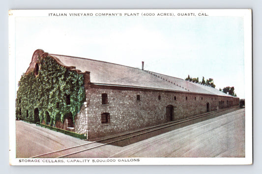 Italian Vineyard Company plant in Guasti California showing long stone wine cellar building with ivy-covered corner and adjacent rail line, early twentieth-century view