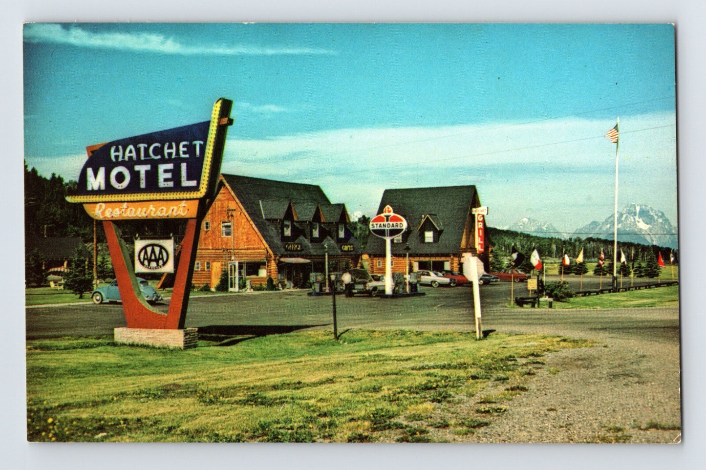 1960s Moran Wyoming Hatchet Motel Restaurant roadside sign Standard Oil gas pump cabins with Teton Range in background postcard