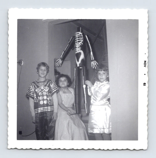 three children Halloween costumes skeleton decoration indoor November 1961 black and white photo