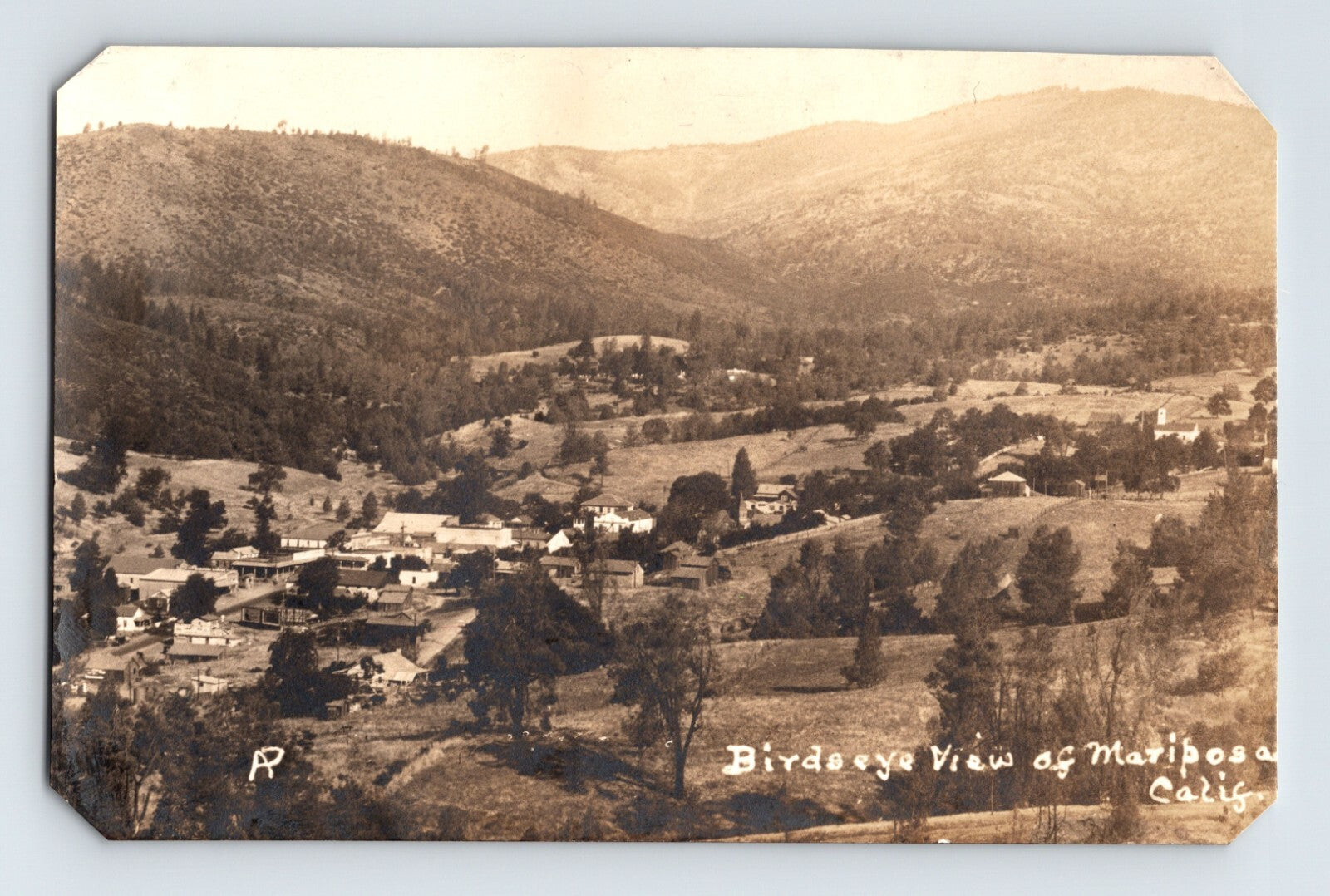 Mariposa California bird’s-eye landscape view showing town buildings, rolling hills, and scattered trees, real photo postcard 1930s