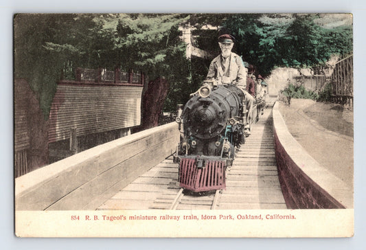 1910s postcard of R. B. Tageol’s miniature railway train crossing a wooden trestle at Idora Park in Oakland, California, engineer seated at front