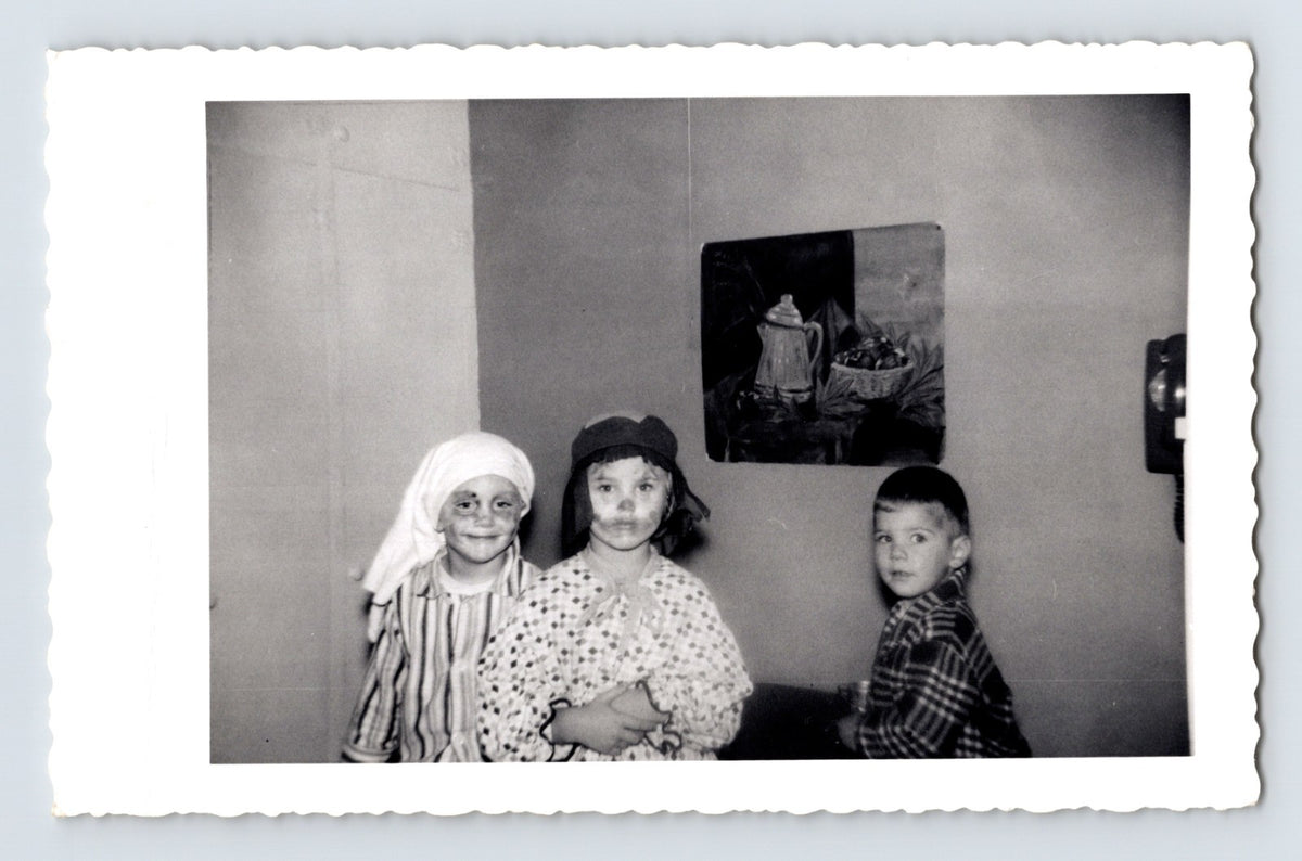 Three children Halloween costumes indoors headscarves striped shirt October 1957 snapshot black and white