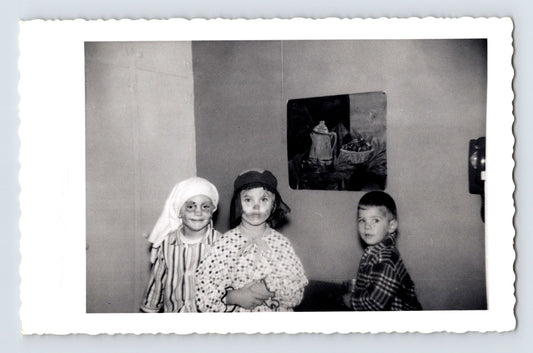 Three children Halloween costumes indoors headscarves striped shirt October 1957 snapshot black and white