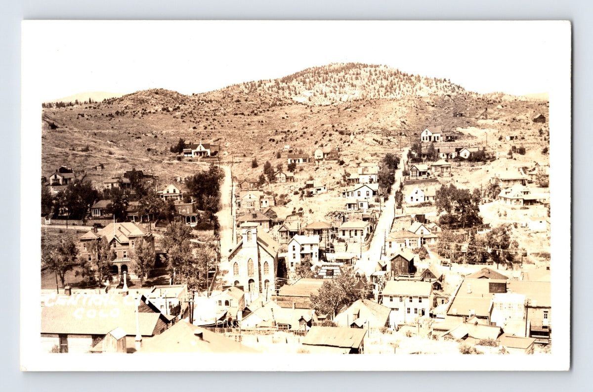 Real photo postcard showing aerial view of Central City Colorado downtown with church and hillside homes, 1930s AZO back unposted