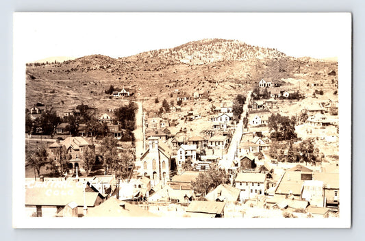 Real photo postcard showing aerial view of Central City Colorado downtown with church and hillside homes, 1930s AZO back unposted