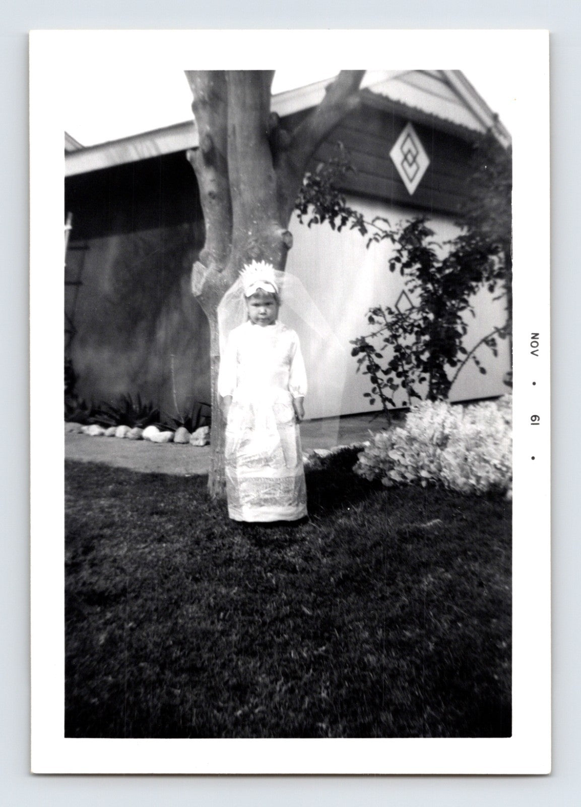Girl Halloween angel costume veil dress yard tree house exterior November 1961 snapshot photo