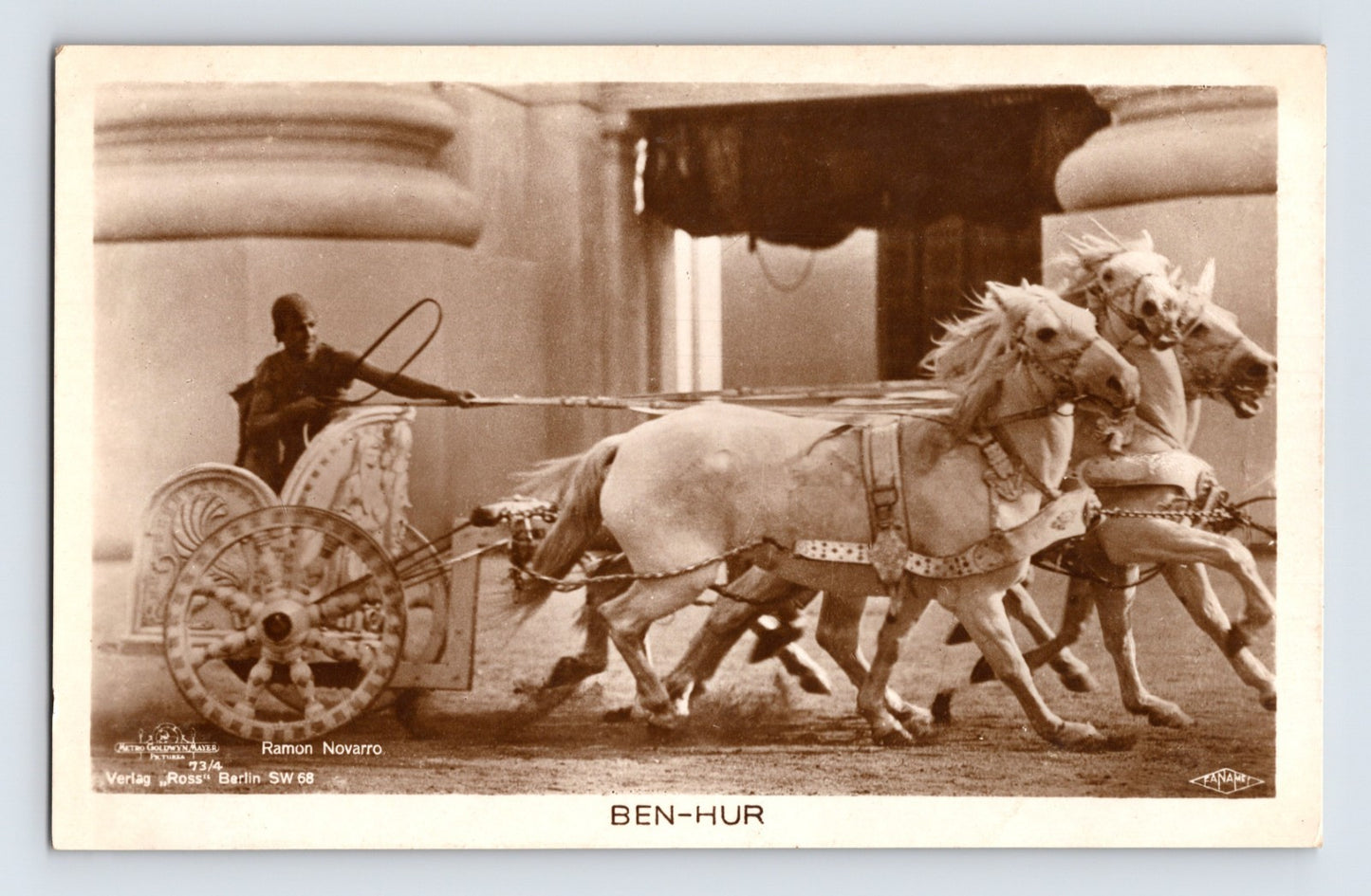 Sepia real photo postcard of Ramon Novarro in chariot scene from Ben Hur with four white horses in motion