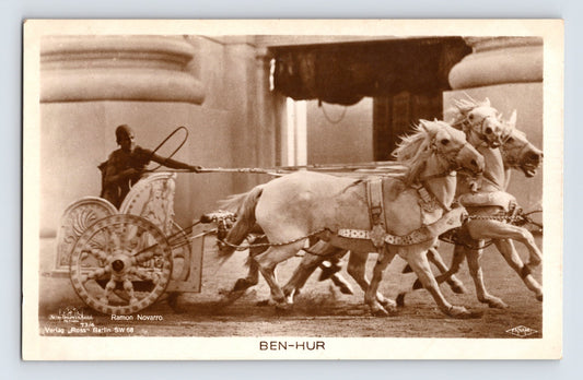 Sepia real photo postcard of Ramon Novarro in chariot scene from Ben Hur with four white horses in motion