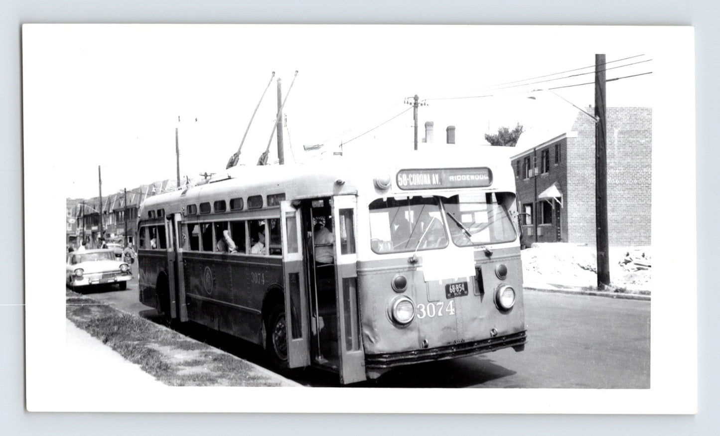 New York City trolley coach 3074 Route 58 Corona Avenue Ridgewood with passengers boarding in Queens residential street scene black and white transit photo