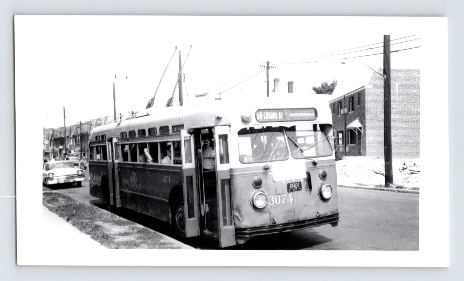 New York City trolley coach 3074 Route 58 Corona Avenue Ridgewood with passengers boarding in Queens residential street scene black and white transit photo