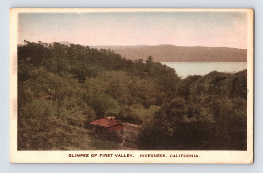 Hand-colored postcard of First Valley in Inverness California with wooded hills and Tomales Bay