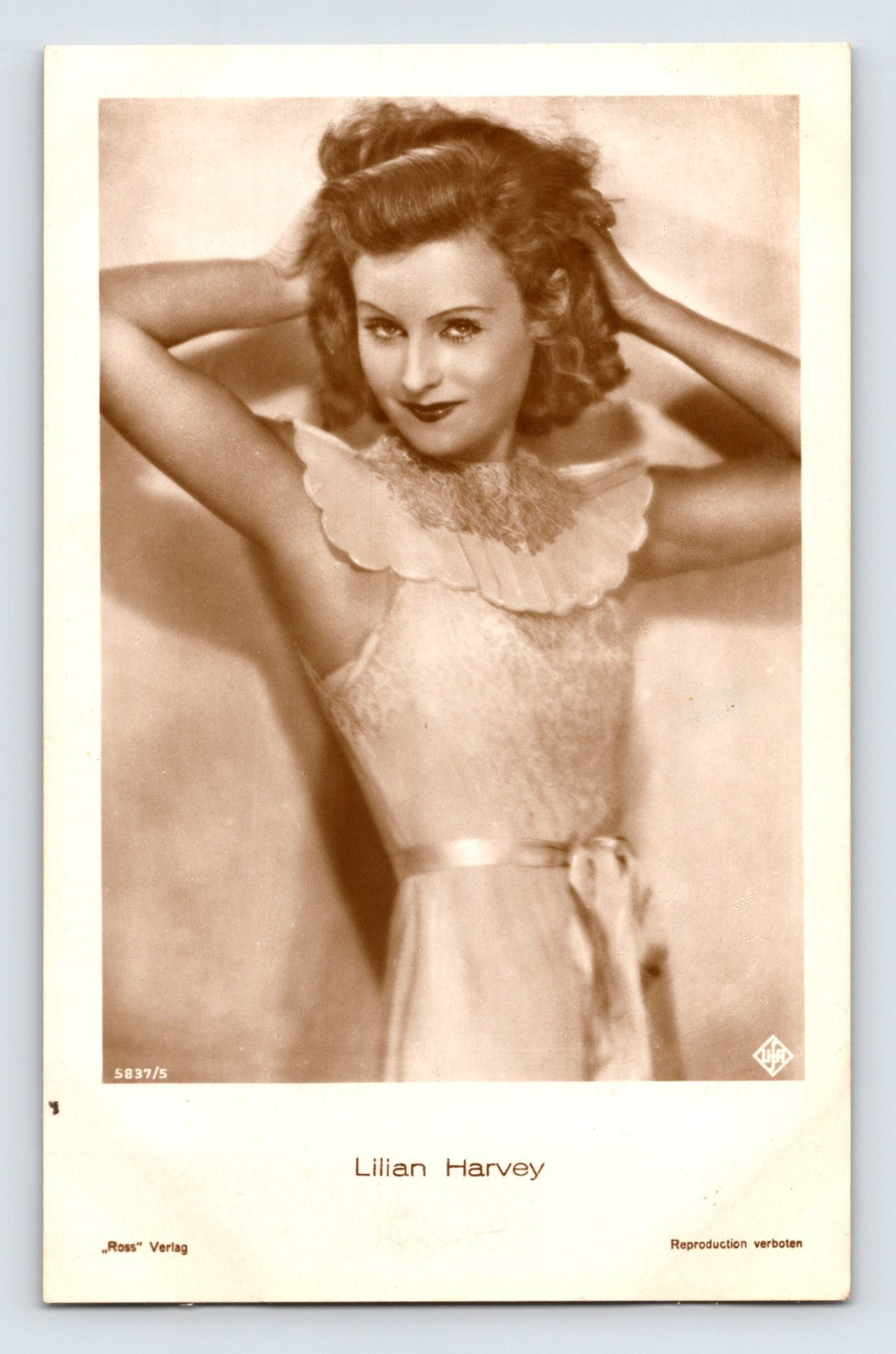 Lilian Harvey portrait photo postcard by Ross Verlag, 1930s sepia studio image with arms raised pose and printed name below image