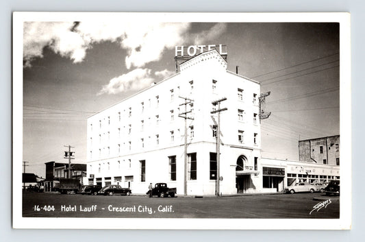 1940s RPPC of Hotel Lauff in Crescent City California showing multi-story corner hotel building with parked cars and truck along street intersection