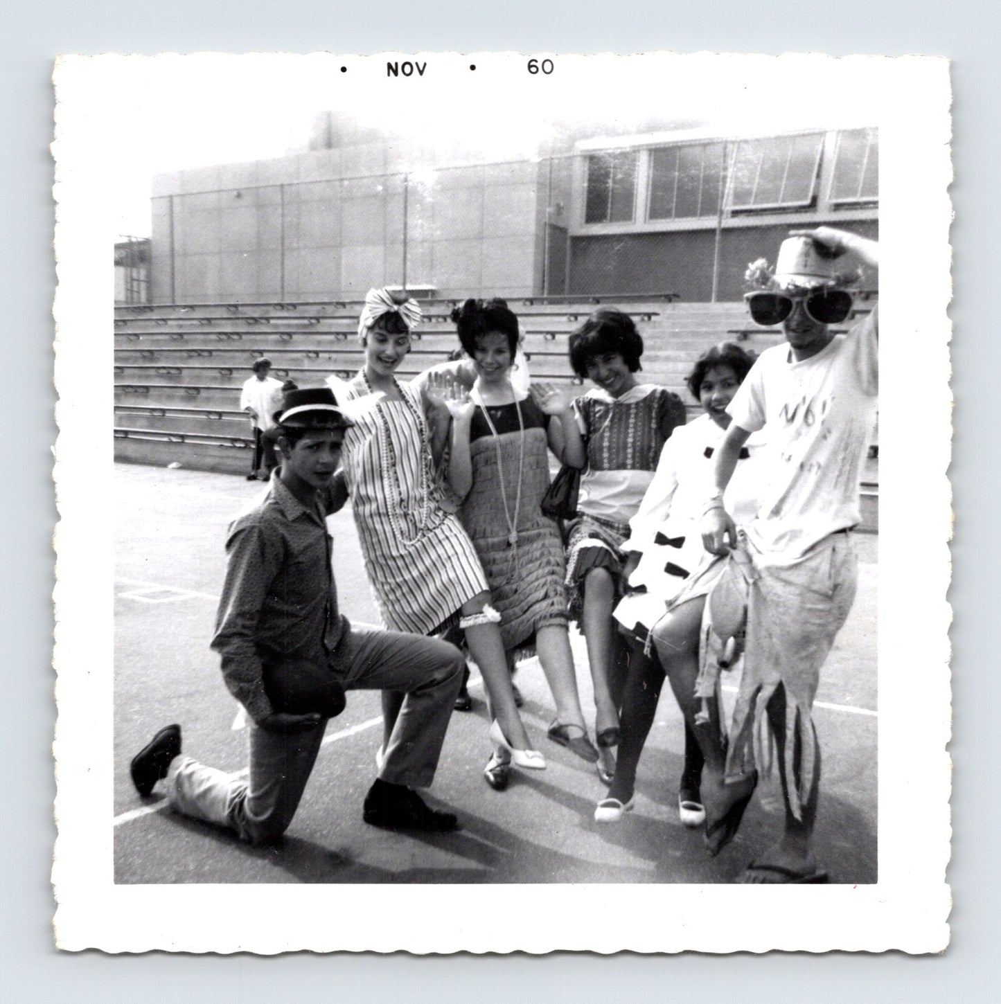 Halloween 1960 teenagers costumes posing outdoors bleachers novelty hats dresses group snapshot vintage photo