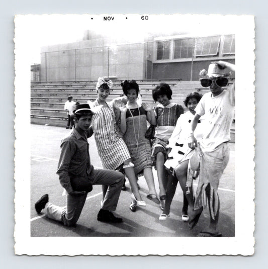 Halloween 1960 teenagers costumes posing outdoors bleachers novelty hats dresses group snapshot vintage photo