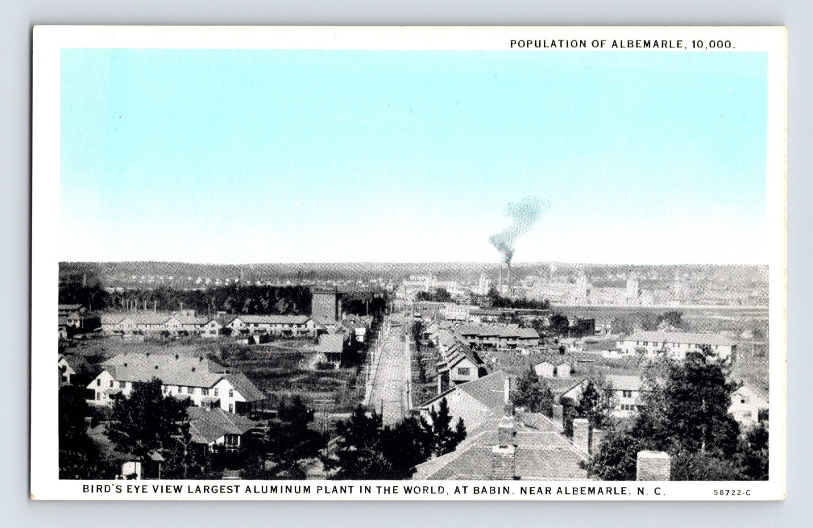 Bird’s-eye view of aluminum plant and townscape in Albemarle, North Carolina, with factory smoke plume in distance, 1930s.