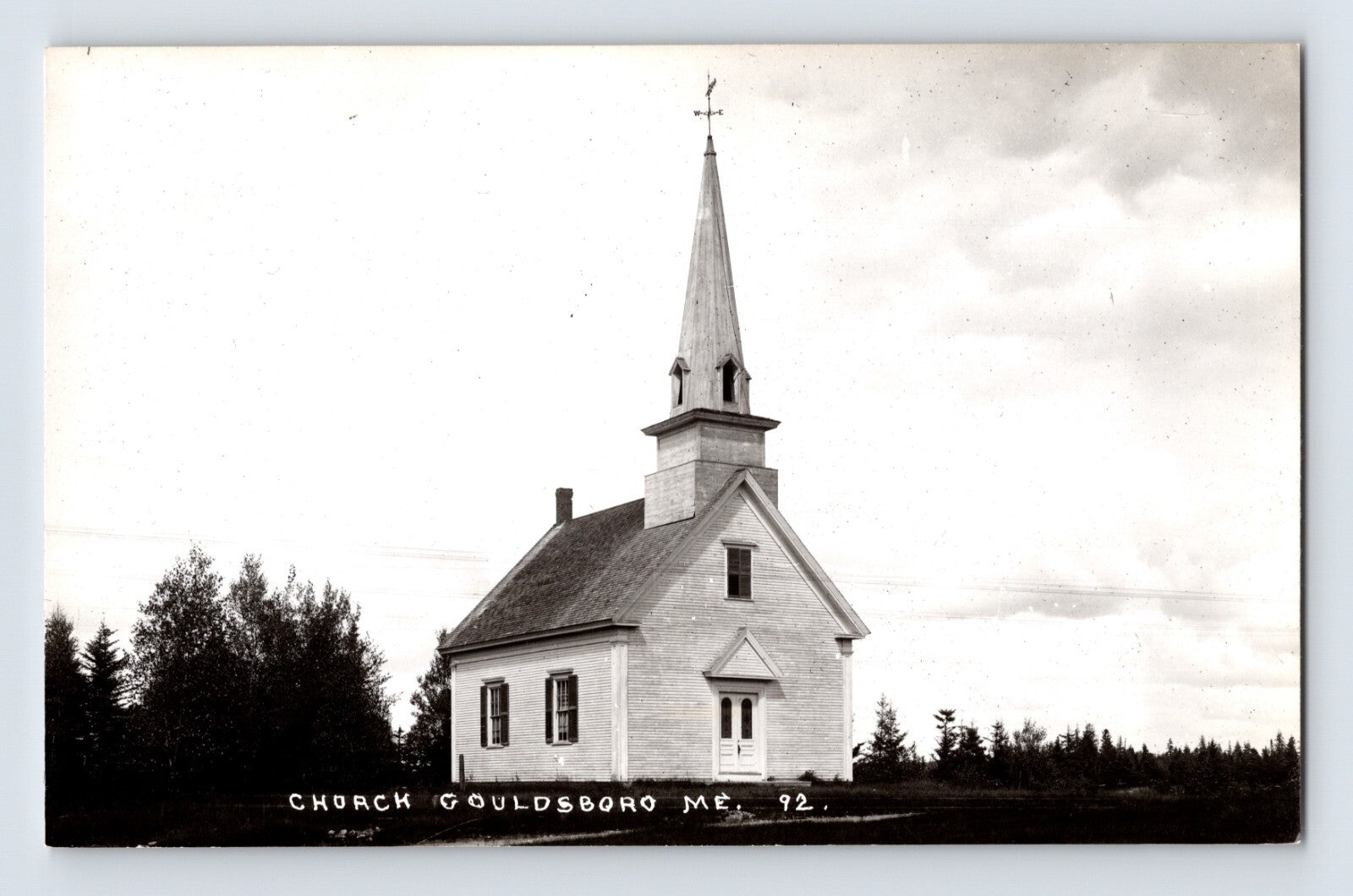 1950s Gouldsboro Maine church real photo postcard with white wooden chapel steeple and cross set against rural tree line