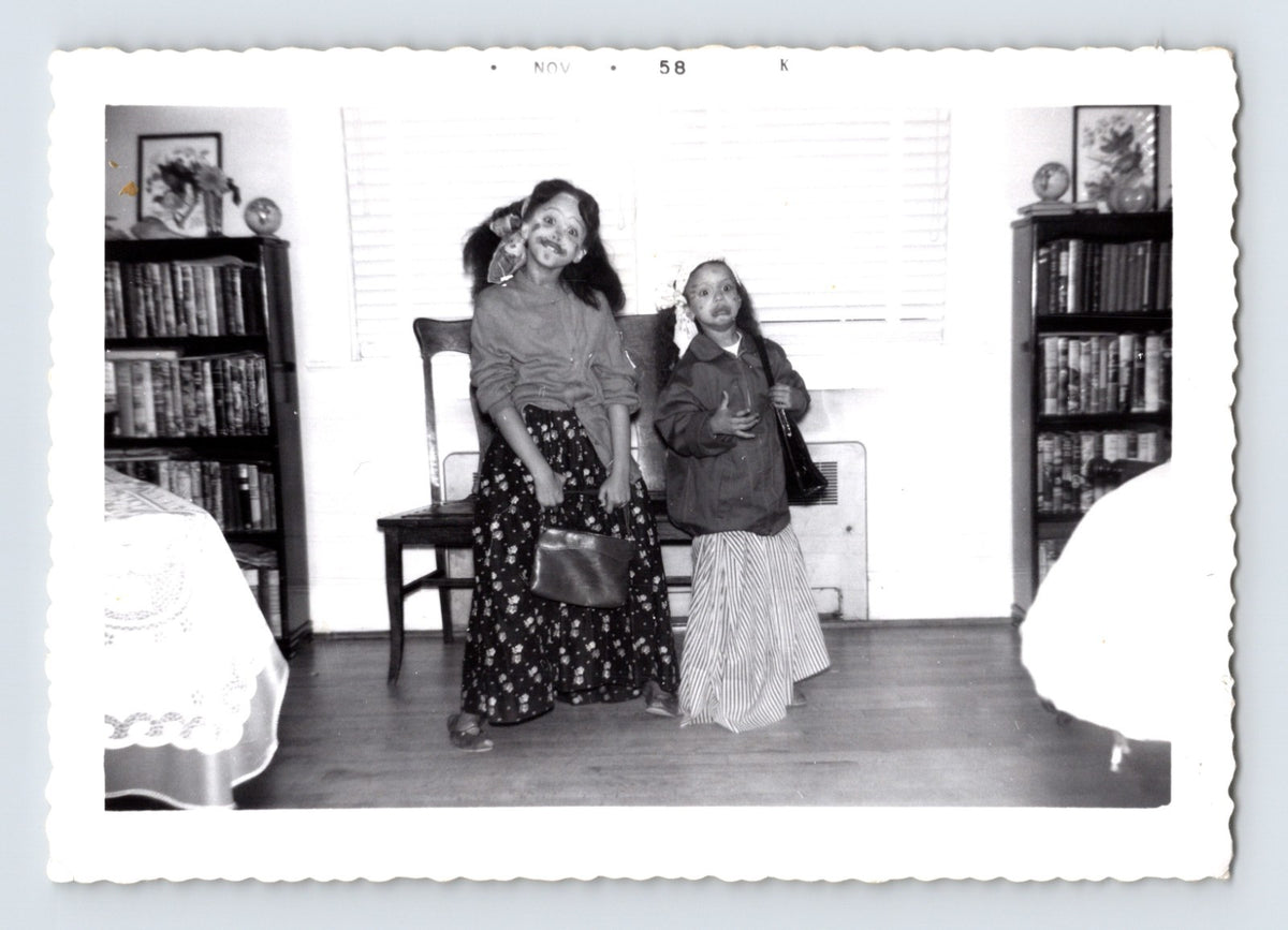 Two girls Halloween costumes face paint holding purses indoor living room 1958 snapshot photo
