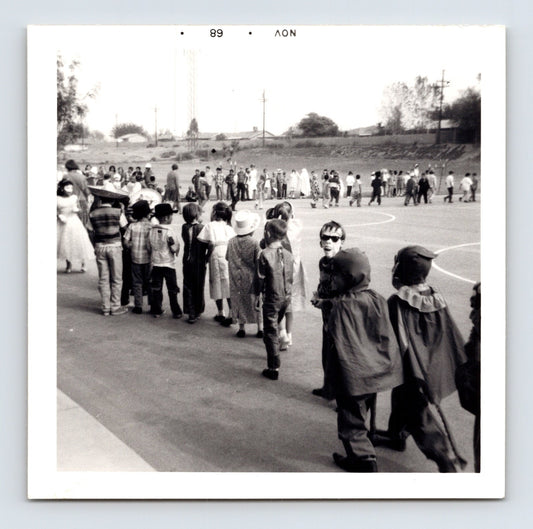 Halloween school parade children costumes line playground capes cowboy hats masks 1960s snapshot 3.5 x 3.5 photo