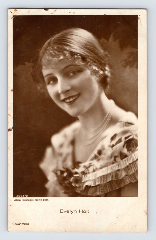 1930s postcard portrait of silent film actress Evelyn Holt wearing a patterned dress and pearl necklace in a softly lit studio publicity photograph published by Ross Verlag.
