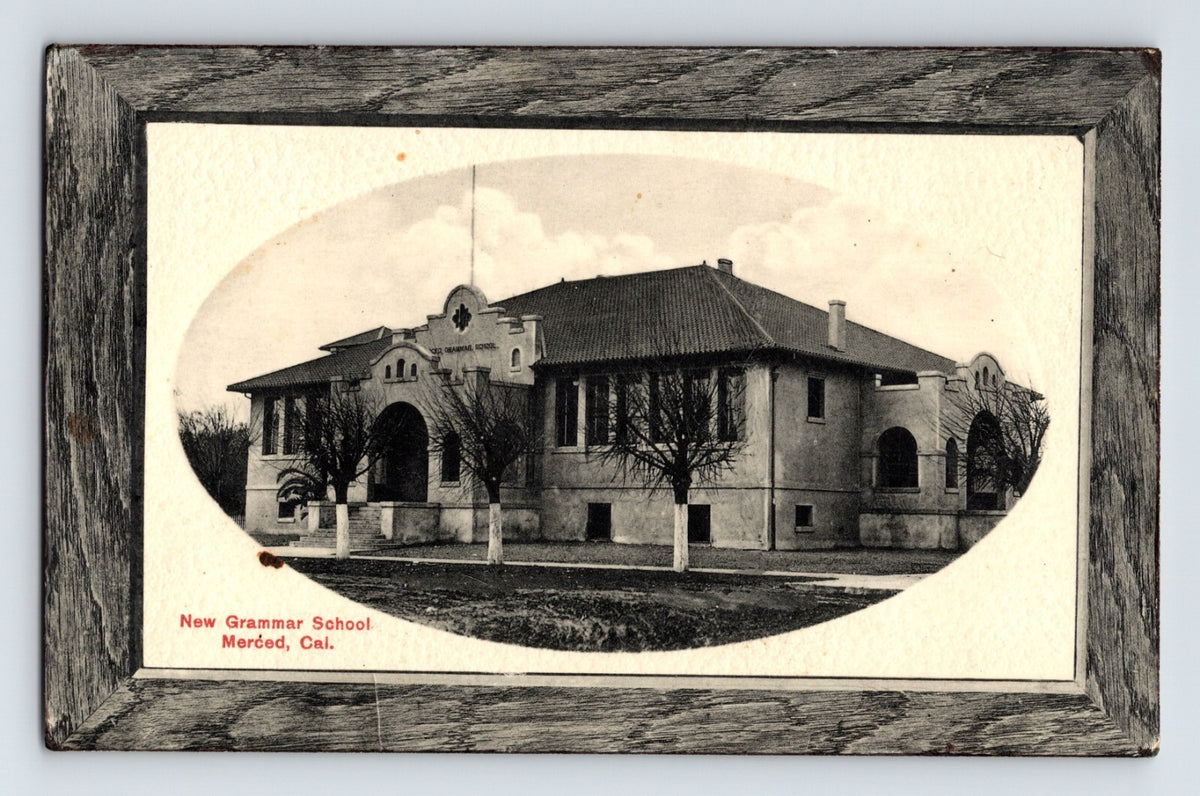 Black and white postcard of New Grammar School in Merced California with oval image and printed frame border