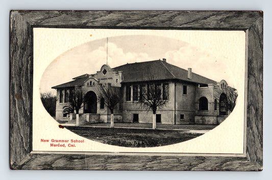 Black and white postcard of New Grammar School in Merced California with oval image and printed frame border