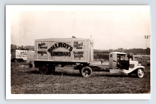 1939 photograph of Billroys Comedians truck and trailer with painted show lettering parked on grassy lot