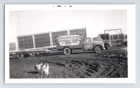 Kelly Miller Circus 1960 photograph showing truck hauling bleacher sections on dirt lot with circus lettering and small dog in foreground Hugo Oklahoma