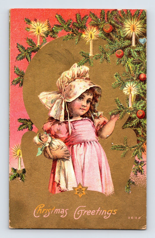 Girl holding doll beneath candle-lit evergreen Christmas garland 1910s postcard