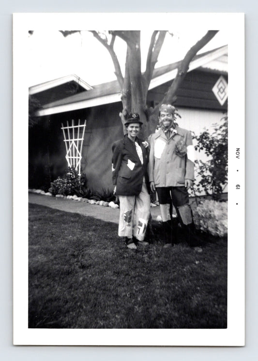 Two boys Halloween costumes patched clothes masks yard house exterior November 1961 snapshot photo