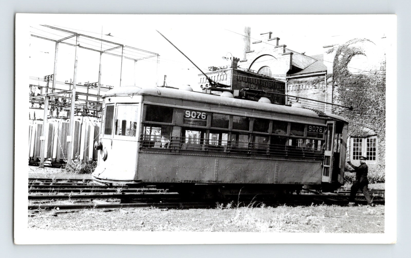 Black-and-white photograph of Stark Electric Railway streetcar number 9076 in Canton, Ohio, showing an interurban trolley beside electrical infrastructure and rail yard tracks.