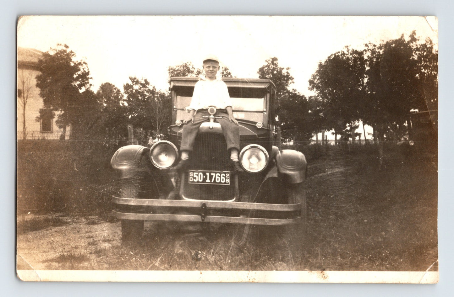 Boy sitting on Ford Model T automobile with South Dakota license plate 1928 vintage photograph