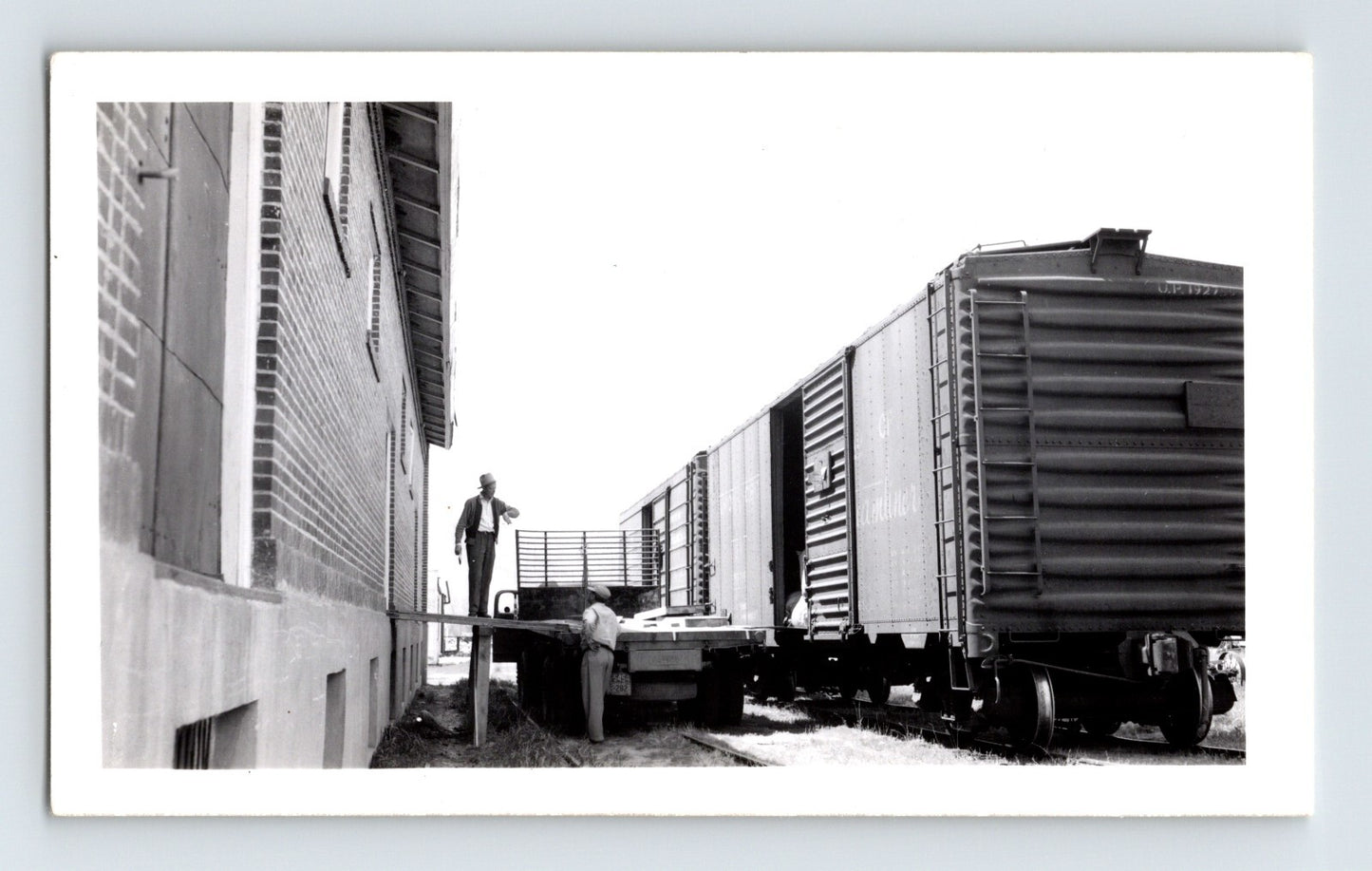 Black-and-white railroad photograph showing freight cars being loaded beside a warehouse on the Nevada County Narrow Gauge Railroad line in Minden, Nevada.