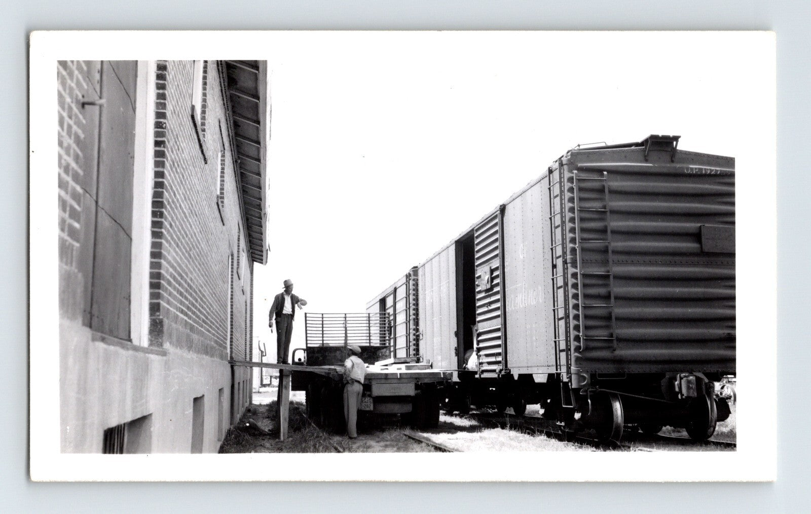Black-and-white railroad photograph showing freight cars being loaded beside a warehouse on the Nevada County Narrow Gauge Railroad line in Minden, Nevada.