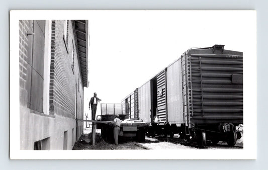 Black-and-white railroad photograph showing freight cars being loaded beside a warehouse on the Nevada County Narrow Gauge Railroad line in Minden, Nevada.