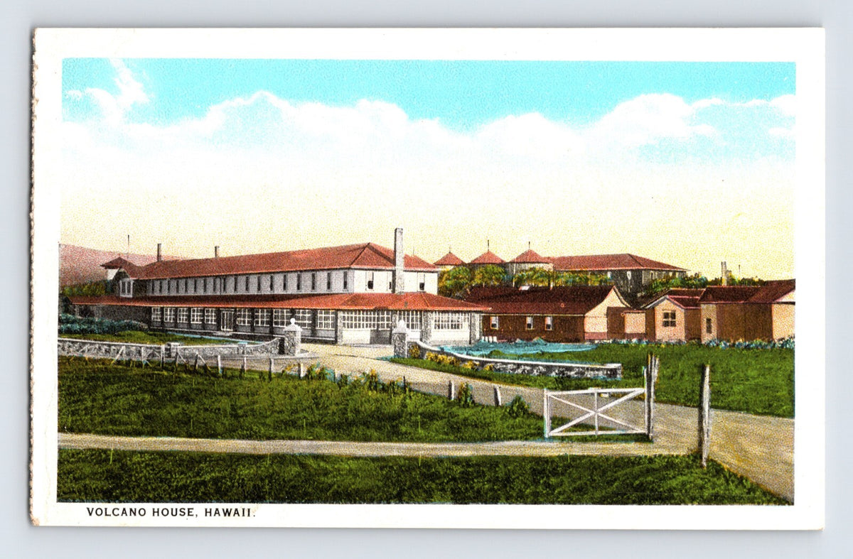 Volcano House Hotel in Hawaii showing long red roofed building, landscaped grounds, and fenced entry in white border postcard